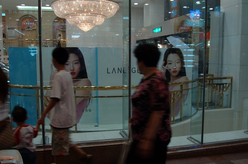 時光倒轉 王啟瑞<br>地點：民族路新光三越百貨<br/>站在櫥窗前等了許久，就是拍不到適當的人物。後來乾脆回家載老媽來當路人甲，可惜感覺還是不對，可見路人甲也不好當。<br/>對不起阿母啊！我最後還是選了別人。<br/><br/>(阿母OS：你這個不肖子，想當年我沒生你之前也是個大美女，比賽獎品Leica相機給了老婆，怎麼禮券沒給你老母買化菻~！)<br/>