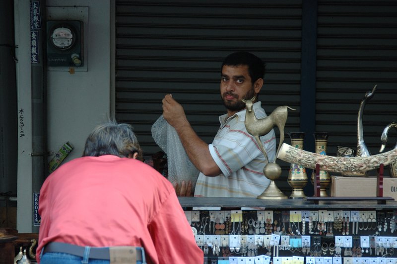 有故事的人 王啟瑞<br>地點:成功路光復市場<br/>市場間一個很特別的攤子，兩個外國人正在整理貨品。看起來像土耳其人(因為我剛去土耳其回來的錯覺吧)，我站遠遠的拍下他們工作的身影，然後微笑道謝離開。<br/>