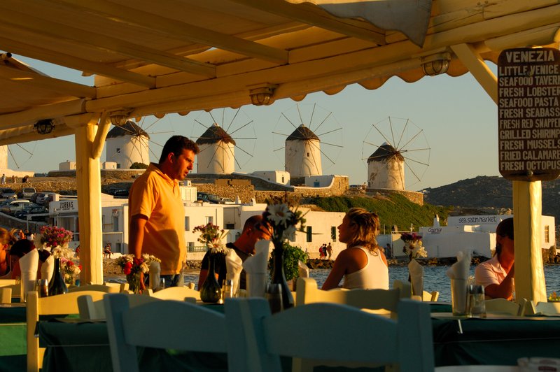 Mykonos米克諾斯<br>先生：你們是土匪啊，這menu上的價格太嚇人啊！服務生：這裡是看夕陽最好的位置，背後又是有名的風車。太太：別抱怨啦，人家一輩子才來一次愛琴海。<br/>