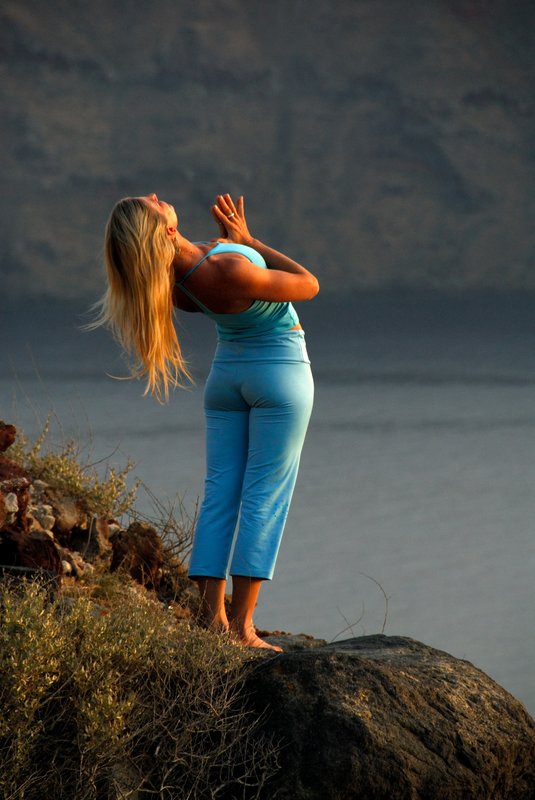 Oia 伊亞<br>這一天伊亞的落日不太精采，太陽早早就落入厚厚的雲層裡。幸好這位在深崖旁表演瑜珈的女子，稍稍補償了大家樂趣。<br/>