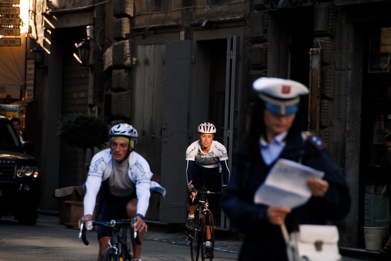 Cortona 科托納<br>清晨時刻，金黃色的陽光穿透雲縫間照射在路面上。兩位自行車手，自動的騎到我期待的位置，身上的光線，恍若是刻意打光的結果。<br/>