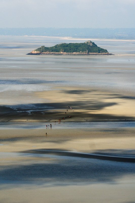 聖米歇爾山Mont-Saint-Michel<br>退潮的沙洲上，有許多人隨嚮導走向遠處的小島。<br/>