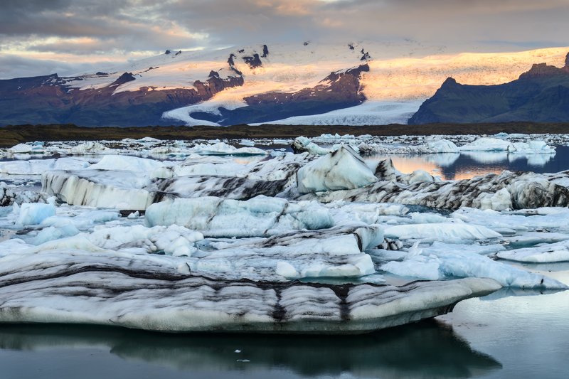 Jokulsarlon Lagoon 冰河湖<br>清晨的陽光照在遠處的冰原上，也反射在湖面上，形成不同色系的光影。