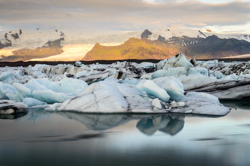 Jokulsarlon Lagoon 冰河湖<br>清晨的陽光照在遠處的冰原上，也反射在湖面上，形成不同色系的光影。