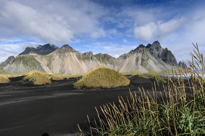 Vesturhorn Mountain<br>黑沙在強風吹襲與沙草保護的作用下，形成了一座座的小土丘。